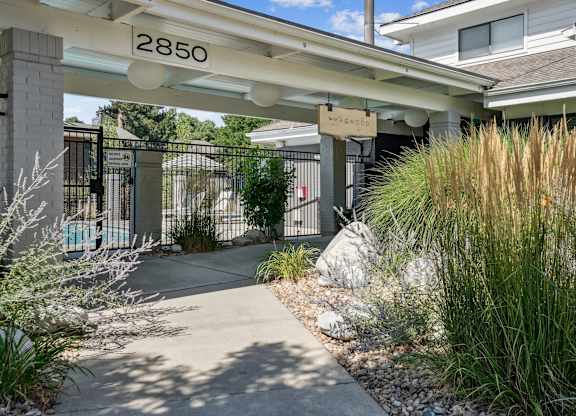 The image shows a pathway leading to a building at The Magwood in Boulder, Colorado.