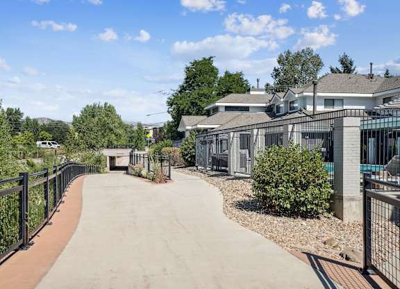Wonderland Creek and Trail pathway with a black fence on both sides leads to a building.