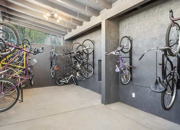 A bike room with many bikes hanging on the wall at The Magwood in Boulder, Colorado.