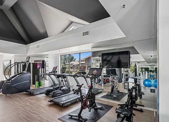 A gym with treadmills, exercise bikes, and a television at The Magwood in Boulder, Colorado.