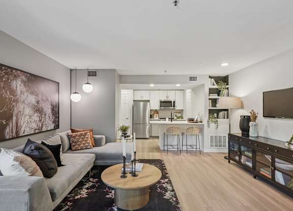 A modern living room with a grey couch and a coffee table.