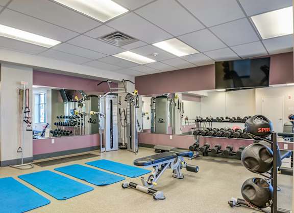 A gym with blue mats on the floor.