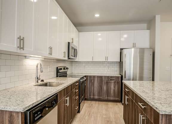 A kitchen with white cabinets and a granite countertop.