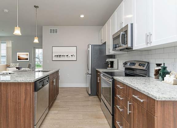 A kitchen with a granite countertop and stainless steel appliances.