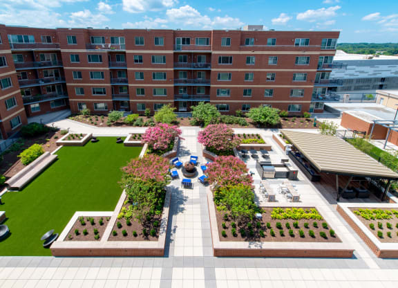 an aerial view of the courtyard of a building with lawns and trees