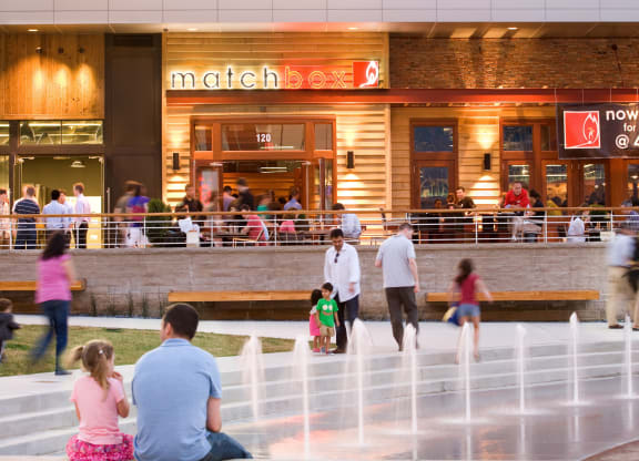 people outside of a mall with a water fountain