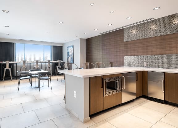 a large kitchen with an island and a dining room with chairs