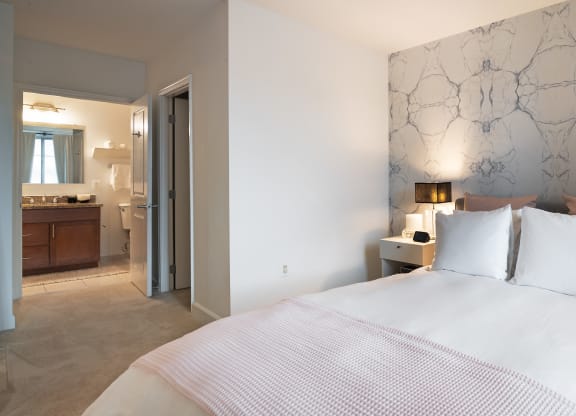 a bedroom with a bed and a bathroom with a sink