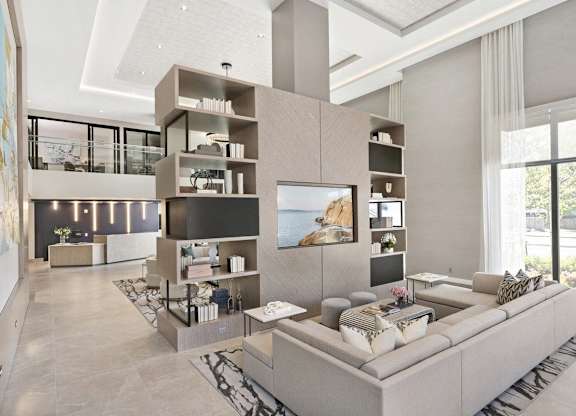 A modern living room with a large grey sofa and a television.