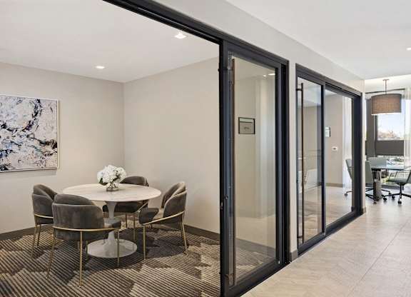 A modern dining room with a glass table and chairs.