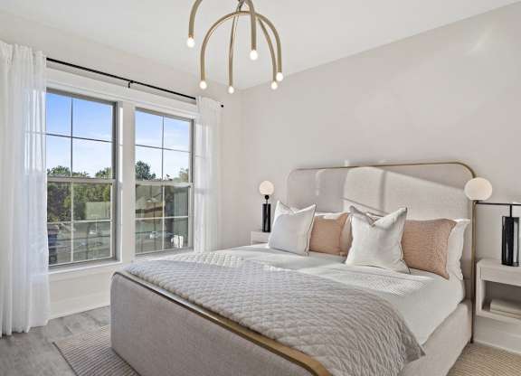 A bedroom with a large bed and a chandelier.