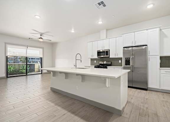 A modern kitchen with white cabinets and a large island.