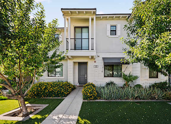 A two-story house with a balcony on the second floor.