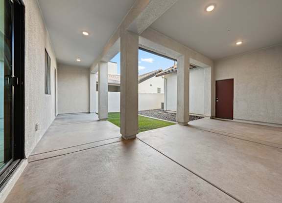 A long hallway with a door on the right and a window on the left.