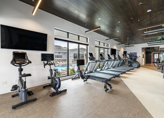 the gym is equipped with cardio equipment and televisions
