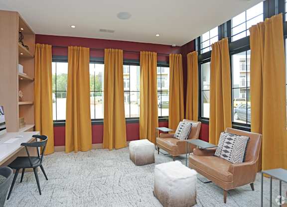 A living room with a brown couch, a white desk, and a chair.at 198 Milltown Apartments, Burlington, NC  