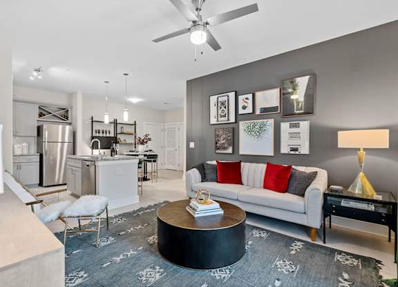 A modern living room with a grey carpet and a white sofa.at 198 Milltown Apartments, North Carolina, 27215