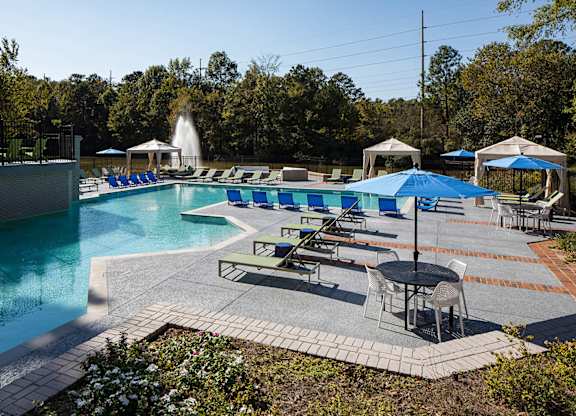 a swimming pool with lounge chairs and umbrellas at Inverness Cliffs, Birmingham, 35242