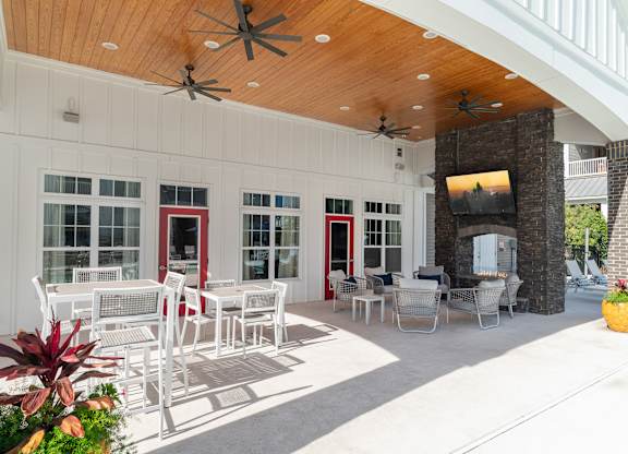 A patio with a white table and chairs and a ceiling fan. at Concord Ridge Apartments, Concord, North Carolina