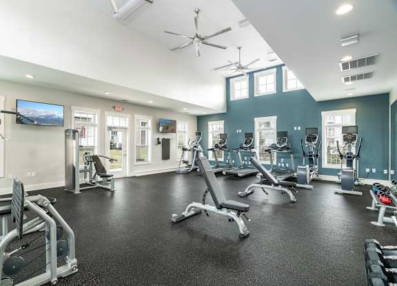 A spacious gym with a variety of equipment and a flat screen TV mounted on the wall. at Concord Ridge Apartments, North Carolina, 28027