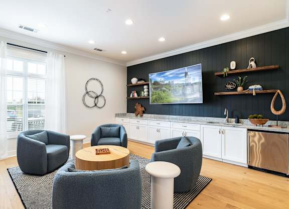 A modern living room with grey armchairs and a wooden coffee table. at Concord Ridge Apartments, North Carolina, 28027