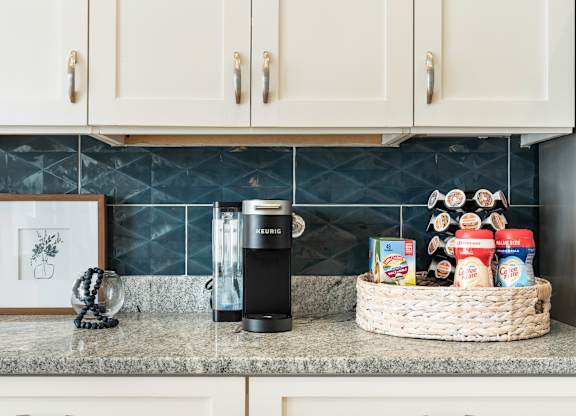 A kitchen counter with a basket of food and a coffee maker. at Concord Ridge Apartments, North Carolina, 28027