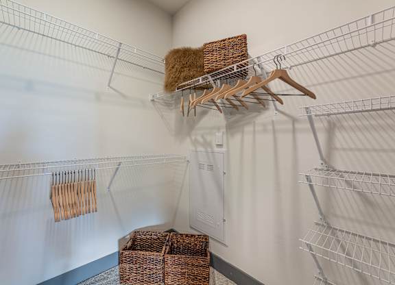 A white closet with a hanger and a basket. at Magnolia Grove Apartments, Terrell, 75160