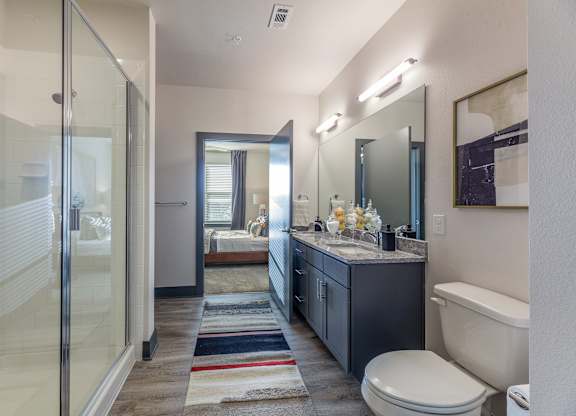 A bathroom with a toilet, sink, and shower. at Magnolia Grove Apartments, Terrell, 75160