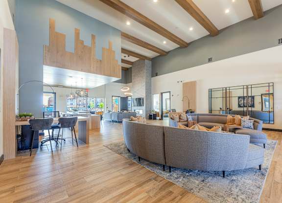A spacious living room with a grey sofa set and wooden flooring. at Magnolia Grove Apartments, Terrell, Texas