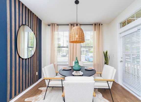a dining room with a table and chairs and a large window at Terraces at Town Center, Jacksonville, Florida