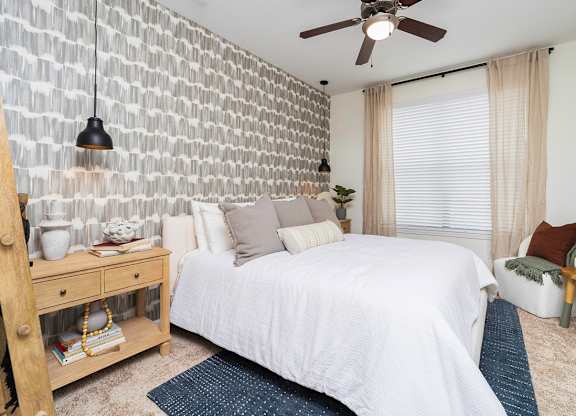 a bedroom with a white bed and a white brick wall at Terraces at Town Center, Jacksonville
