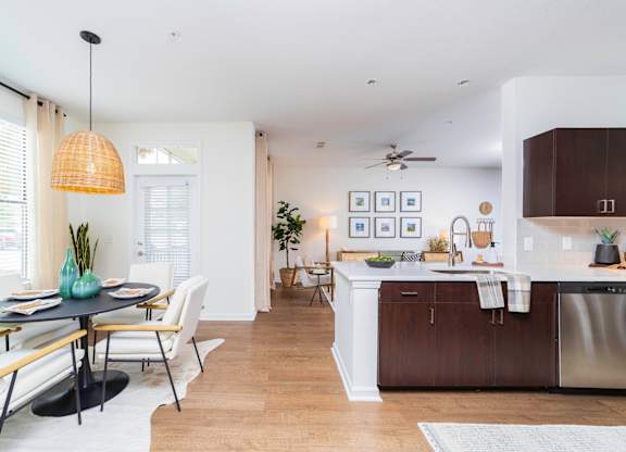 a living room and kitchen with a dining room table and chairs at Terraces at Town Center, Jacksonville