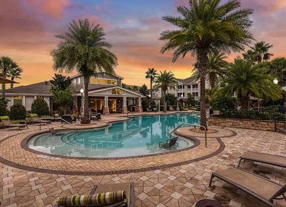 a large swimming pool with palm trees in front of a house at Terraces at Town Center, Jacksonville, 32256