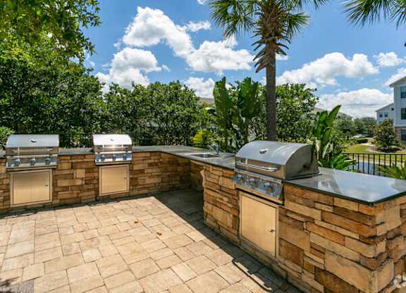 a stone patio with two grills on it at Terraces at Town Center, Jacksonville