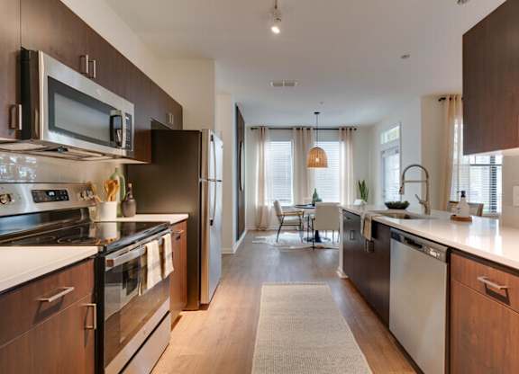 a kitchen with stainless steel appliances and wooden cabinets at Terraces at Town Center, Jacksonville, FL