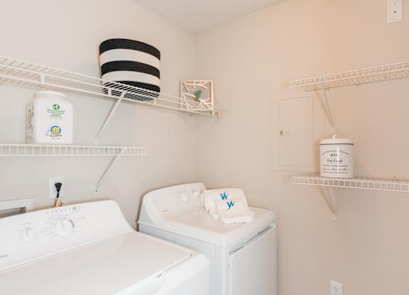 A white washing machine and dryer in a small laundry room. at WildForest Apartments, Alabama, 35209