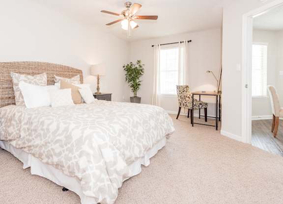 A bedroom with a large bed and a ceiling fan. at WildForest Apartments, Alabama