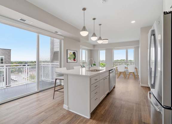 white kitchen with a large island at The Hallon Apartments, Hopkins, 55343