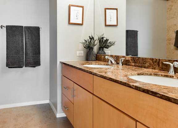 an empty bathroom with two sinks and a mirror at Optima Old Orchard Woods, Illinois