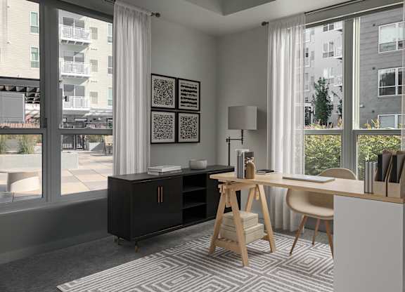 a home office with a desk and a large window