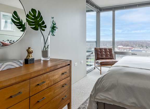 a bedroom with a large window and a bed and a dresser at Optima Old Orchard Woods, Illinois, 60077