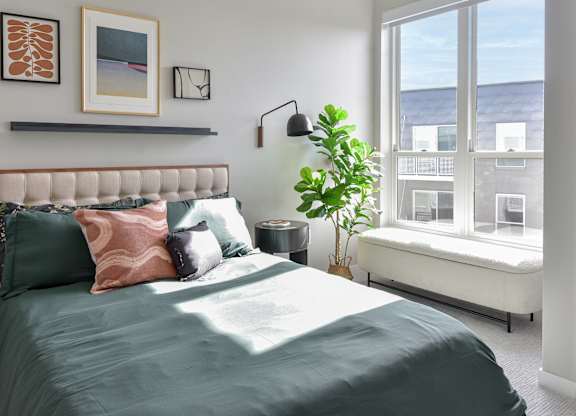 One Bedroom Luxury Apartments in Hopkins, MN - The Hallon - Furnished Bedroom with Plush Carpet Flooring and an Oversized Window