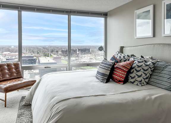a bedroom with a large bed and a view of the city at Optima Old Orchard Woods, Illinois, 60077