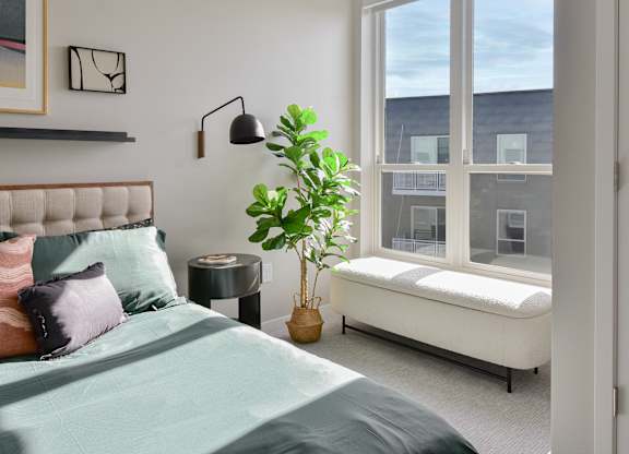 a bedroom with a bed and a large window at The Hallon Apartments, Minnesota