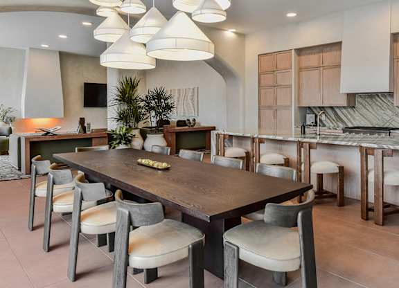 A modern dining room with a large table and chairs.
