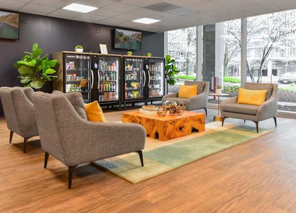 the lobby of a building with chairs and a coffee table at Optima Old Orchard Woods, Illinois