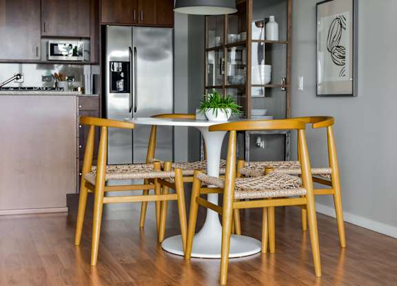 a kitchen with yellow bar stools and a table with high chairs at Optima Old Orchard Woods, Illinois, 60077