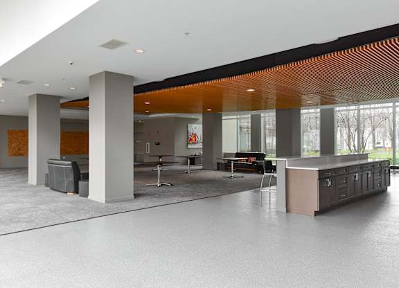the lobby of an office building with a reception desk and large windows at Optima Old Orchard Woods, Skokie, IL