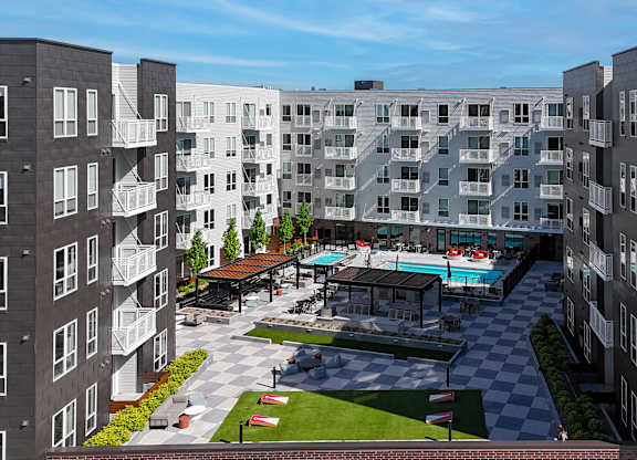 A large apartment complex with a pool and a checkerboard patterned area.