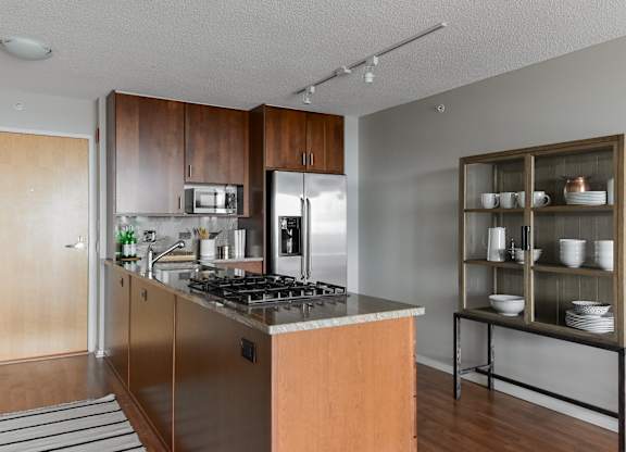 a kitchen with stainless steel appliances and wooden cabinets at Optima Old Orchard Woods, Illinois